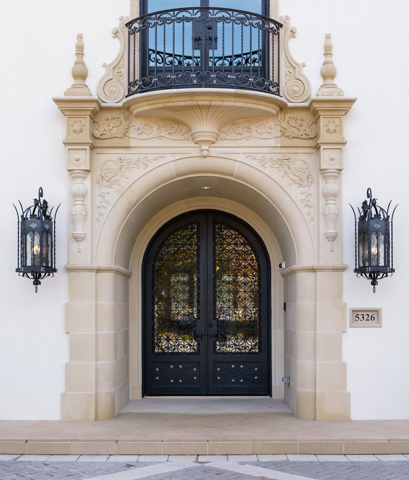 Photo of a large mediterranean front door in Dallas with white walls, limestone floors, a double front door, a black front door and beige floor.