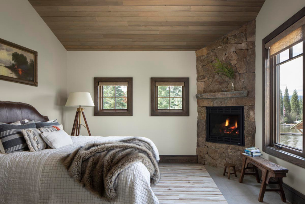 Modernes Hauptschlafzimmer mit Eckkamin, Kaminumrandung aus gestapelten Steinen und Holzdecke in Denver