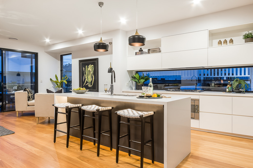 This is an example of a contemporary kitchen in Townsville with an undermount sink, flat-panel cabinets, white cabinets, window splashback, medium hardwood floors, with island and brown floor.