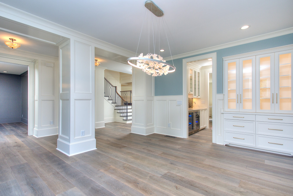 Foto di una grande sala da pranzo classica con pareti blu, pavimento in legno massello medio, pavimento marrone e pannellatura