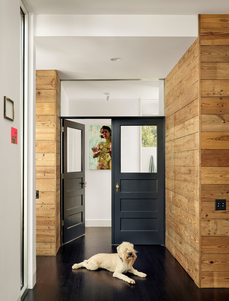 Inspiration for a contemporary hallway in Austin with dark hardwood floors and black floor.