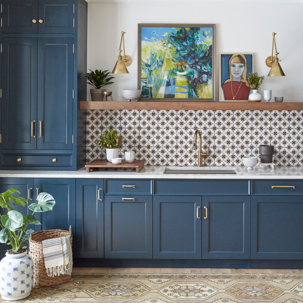 Inspiration pour une arrière-cuisine bohème avec un placard avec porte à panneau encastré, des portes de placard bleues, une crédence blanche, parquet clair, un sol marron et un plan de travail blanc.
