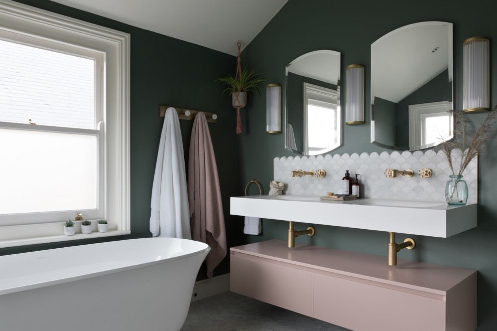 Photo of a mid-sized contemporary master bathroom in Kent with a freestanding tub, an open shower, a wall-mount toilet, green walls, marble floors, solid surface benchtops, an open shower, white benchtops, a niche, a double vanity, a floating vanity and vaulted.
