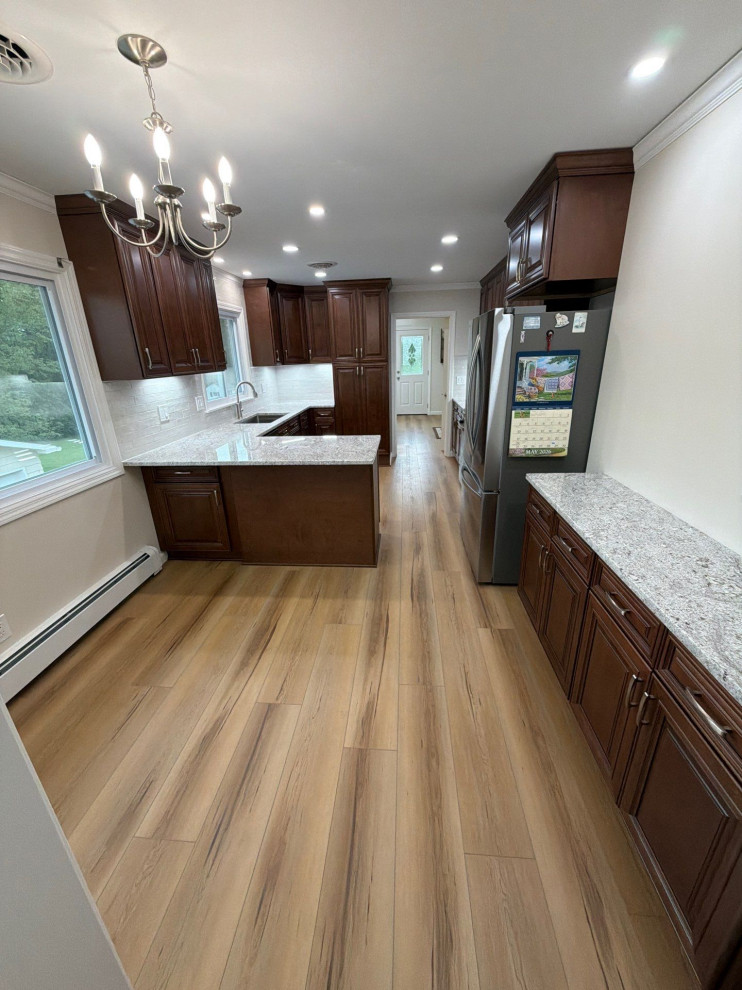 USCD cabinetry accompanied granite countertops, porcelain tile backsplash and Ca