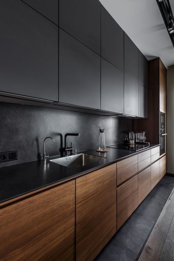 Inspiration for a large modern grey and black l-shaped open plan kitchen in Austin with a double-bowl sink, flat-panel cabinets, concrete worktops, black splashback, cement tile splashback, integrated appliances, light hardwood flooring, an island, brown floors, black worktops and all types of ceiling.