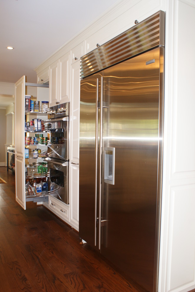 Inspiration for a transitional medium tone wood floor kitchen remodel in Dallas with an undermount sink, white cabinets, granite countertops, beige backsplash, ceramic backsplash, stainless steel appliances, beige walls, two islands and raised-panel cabinets