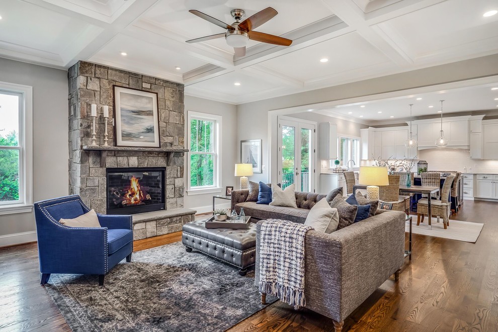 Large arts and crafts open concept family room in DC Metro with grey walls, dark hardwood floors, a standard fireplace, a stone fireplace surround and brown floor.