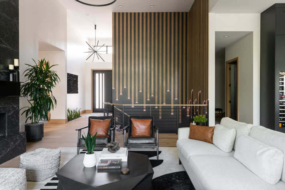 Стильный дизайн: огромная открытая гостиная комната в стиле модернизм с светлым паркетным полом, фасадом камина из плитки, коричневым полом и панелями на части стены - последний тренд