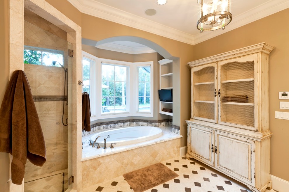 Mid-sized traditional bathroom in Houston with raised-panel cabinets, an alcove tub, a corner shower, beige walls and limestone floors.
