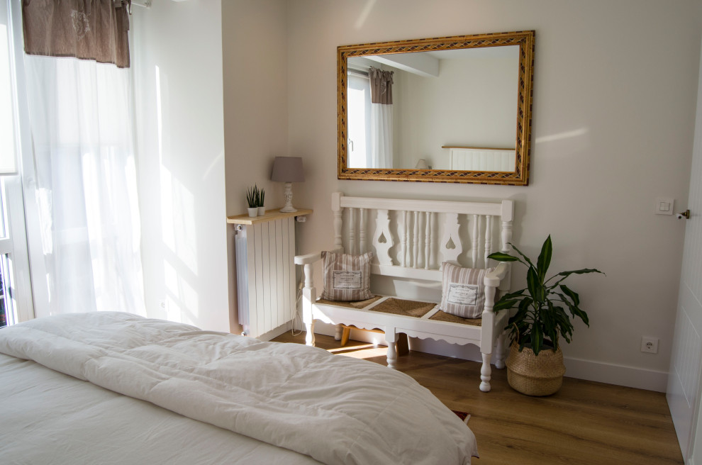 Modelo de dormitorio principal nórdico de tamaño medio con suelo de madera en tonos medios, suelo marrón y papel pintado