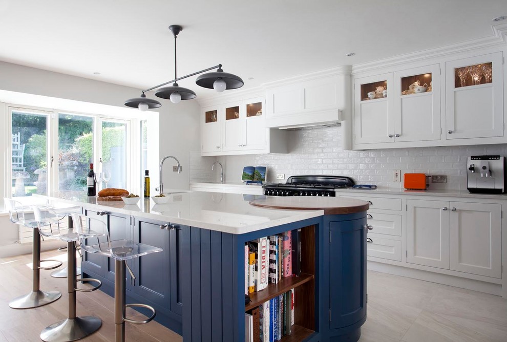 Inspiration for a large beach style galley open plan kitchen in Dublin with shaker cabinets, blue cabinets, quartzite benchtops, ceramic splashback, black appliances, light hardwood floors, with island, an undermount sink and beige floor.