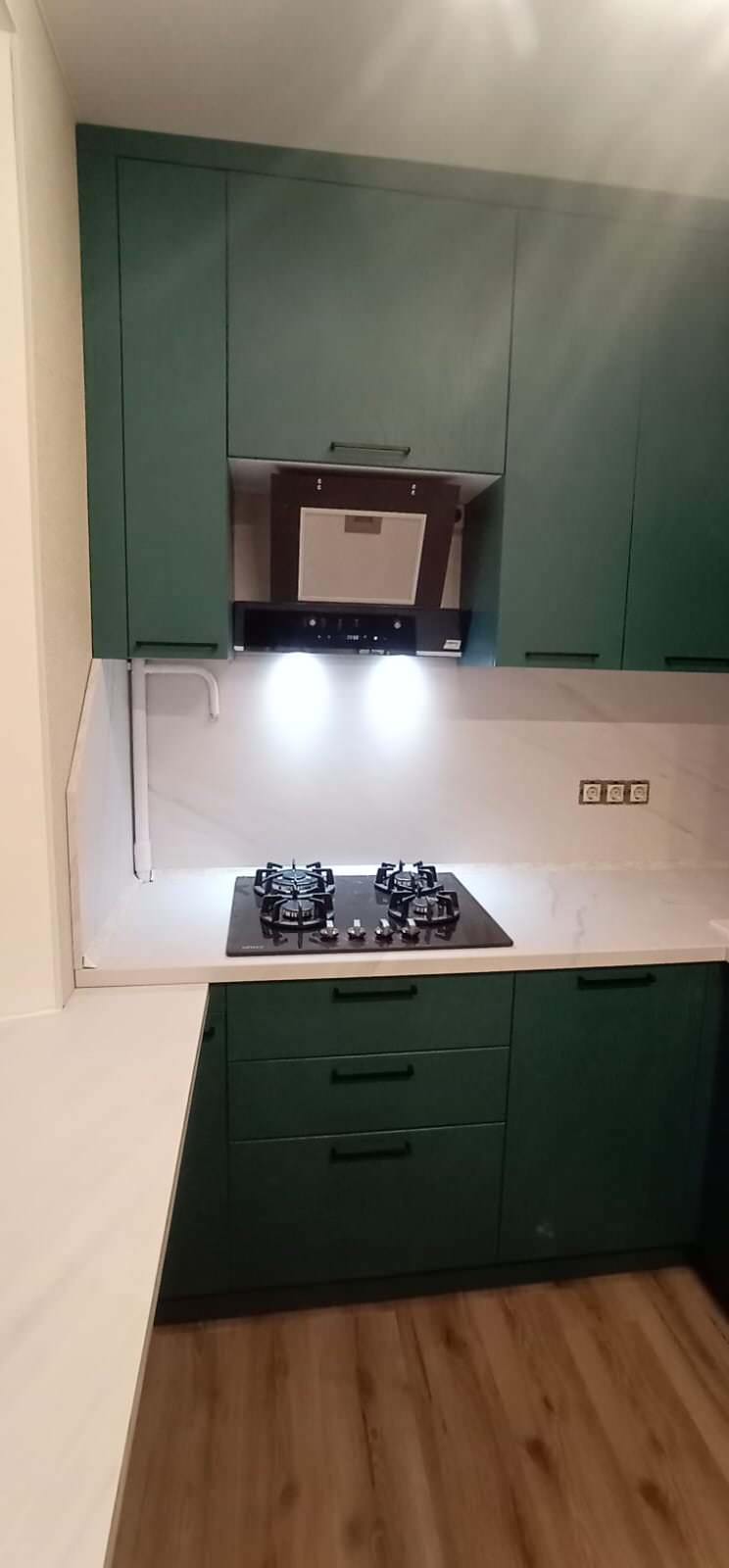 Компактная кухня в зеленом цвете с подоконником-столешницей