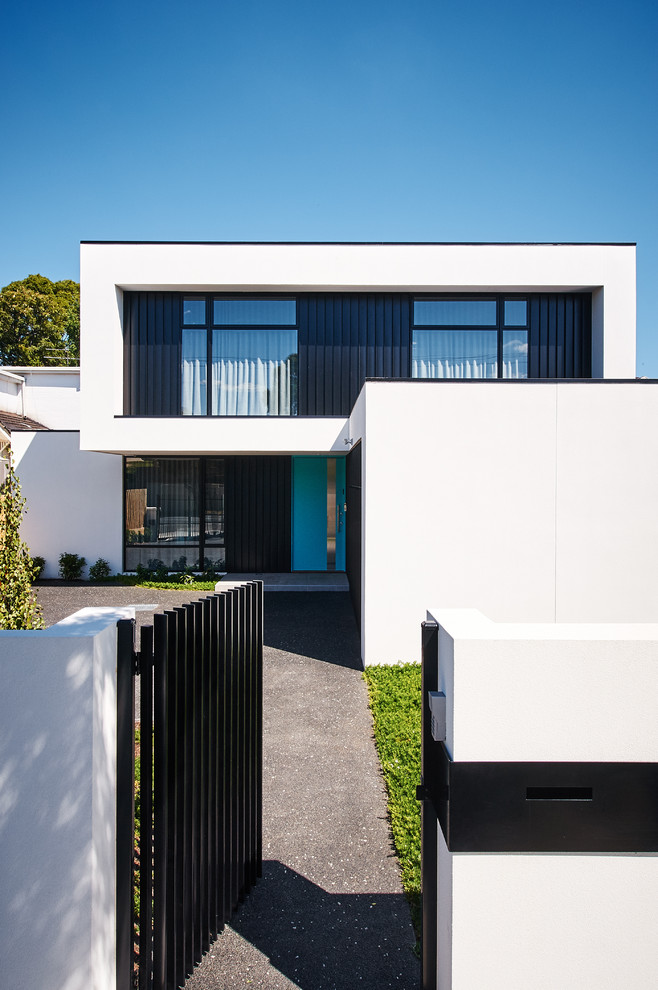 This is an example of a large contemporary two-storey white house exterior in Melbourne with metal siding, a flat roof and a shingle roof.