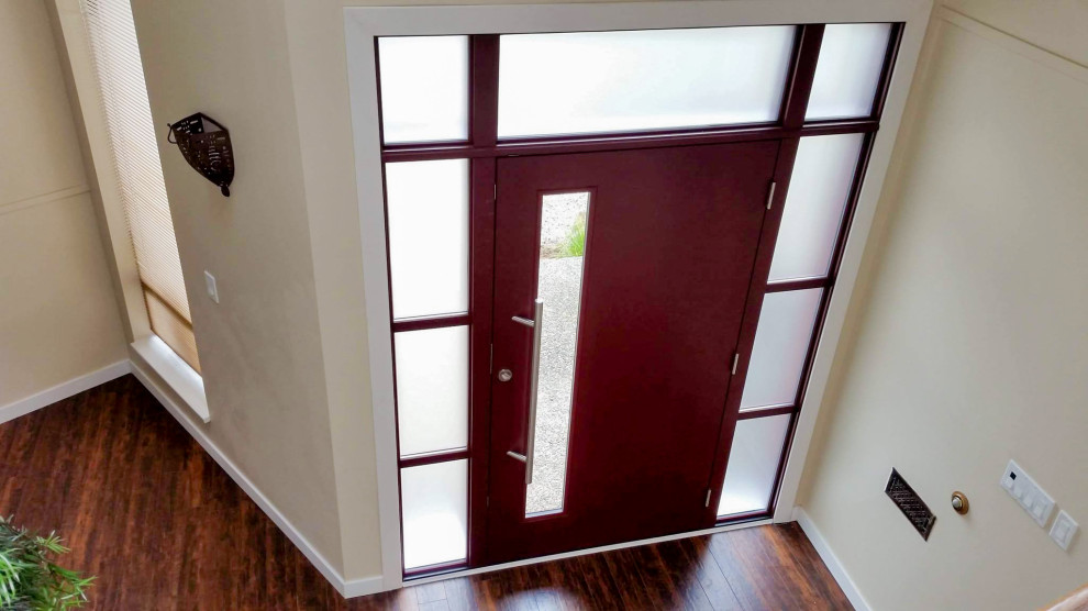 На фото: большая входная дверь в стиле модернизм с белыми стенами, полом из ламината, одностворчатой входной дверью и красной входной дверью с