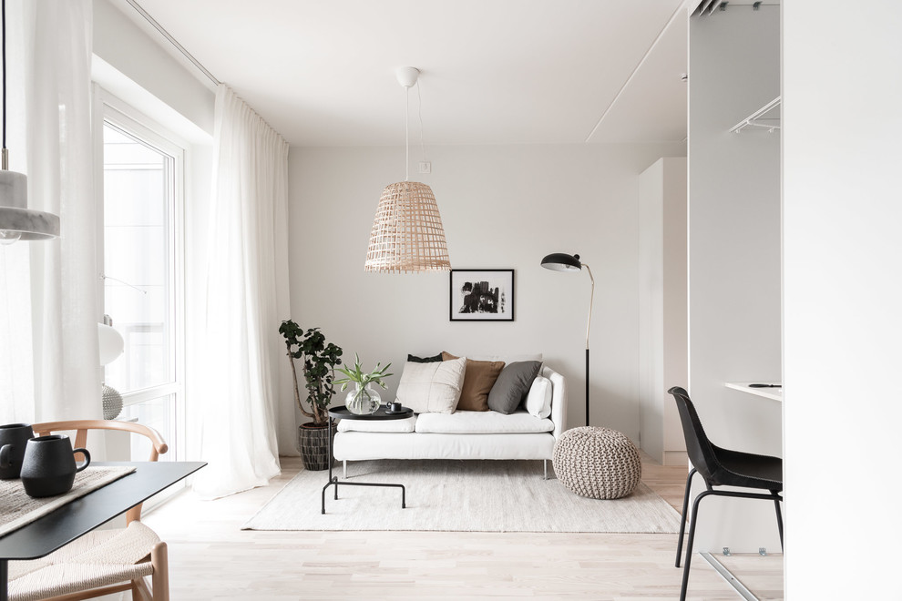 Small scandinavian open concept living room in Gothenburg with white walls, light hardwood floors, no fireplace and beige floor.