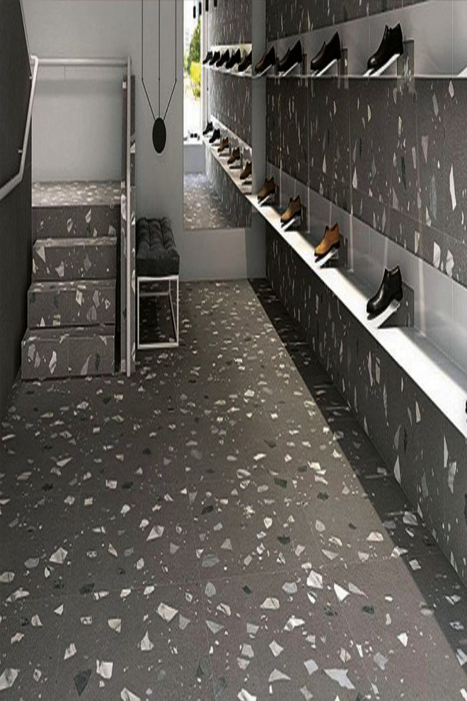 Réalisation d'un grand couloir avec un mur gris, un sol en terrazzo et un sol multicolore.
