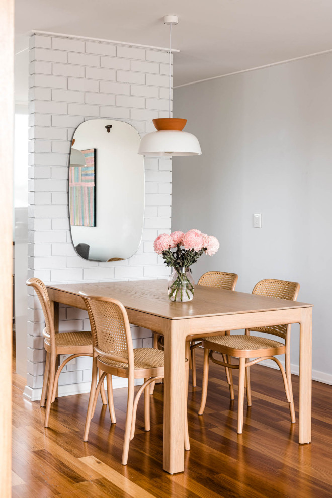 Inspiration for a contemporary dining room in Brisbane with grey walls, medium hardwood floors and brown floor.