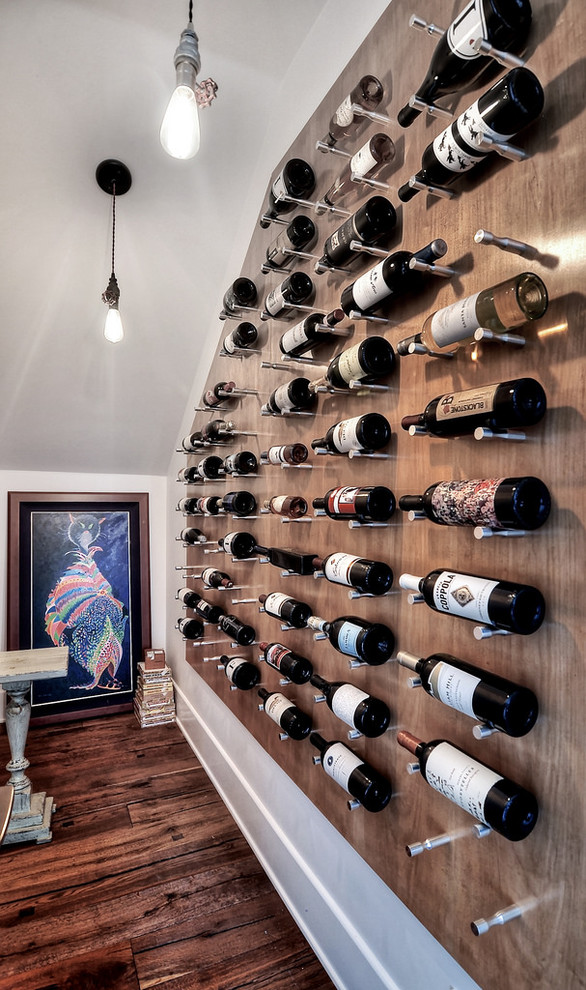 Inspiration for a mid-sized contemporary wine cellar in Orange County with dark hardwood floors, display racks and brown floor.