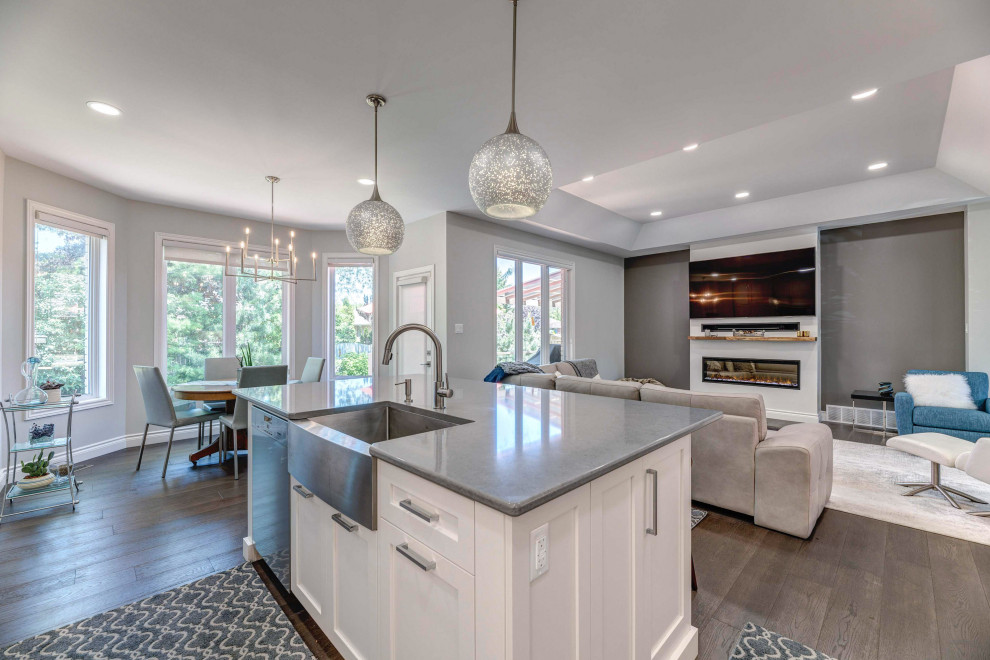 Eat-in kitchen - transitional l-shaped eat-in kitchen idea with a farmhouse sink, shaker cabinets, white cabinets, quartz countertops, porcelain backsplash, stainless steel appliances, an island and white countertops