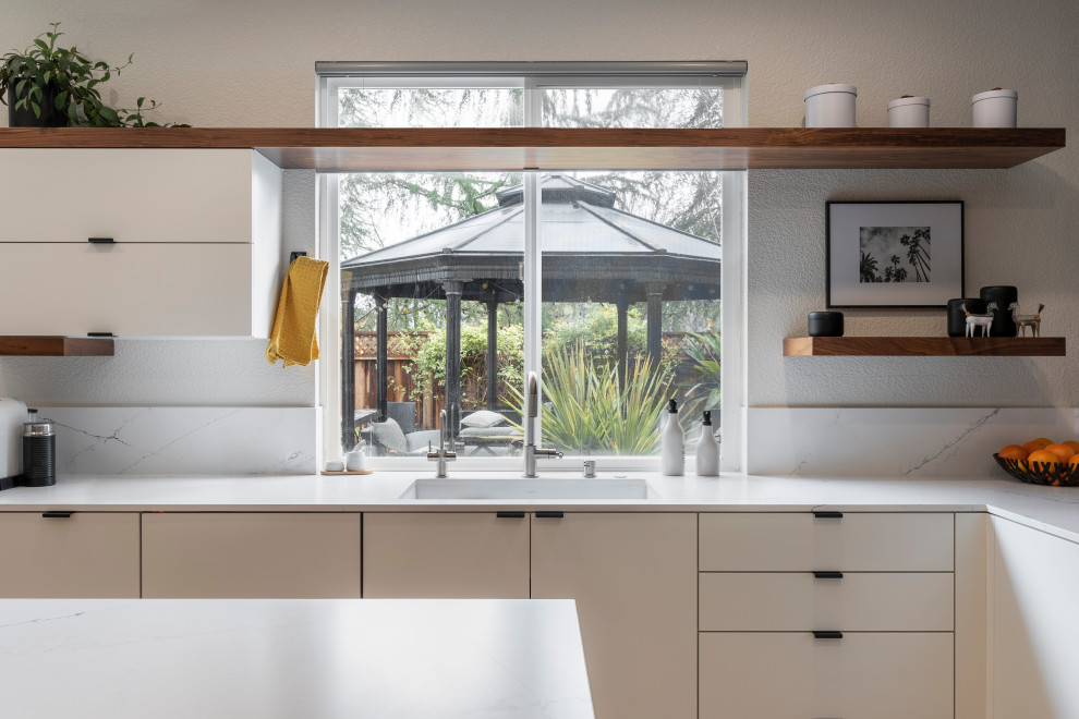 Design ideas for a mid-sized contemporary u-shaped open plan kitchen in Sacramento with an undermount sink, flat-panel cabinets, white cabinets, quartz benchtops, black splashback, porcelain splashback, with island and white benchtop.