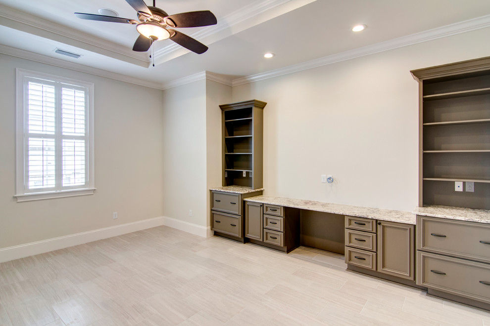 Photo of an expansive traditional study room in Jacksonville with beige walls, porcelain floors, no fireplace, a built-in desk and beige floor.