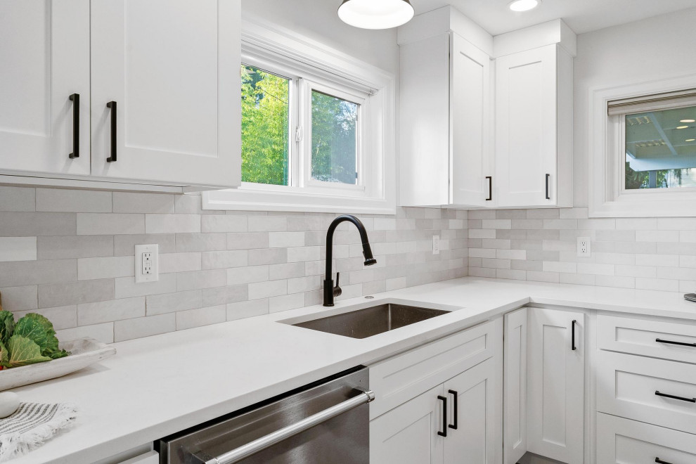 Transitional galley dark wood floor and brown floor laundry room photo in Seattle with an undermount sink, shaker cabinets, white cabinets, quartzite countertops, gray backsplash, ceramic backsplash and white countertops