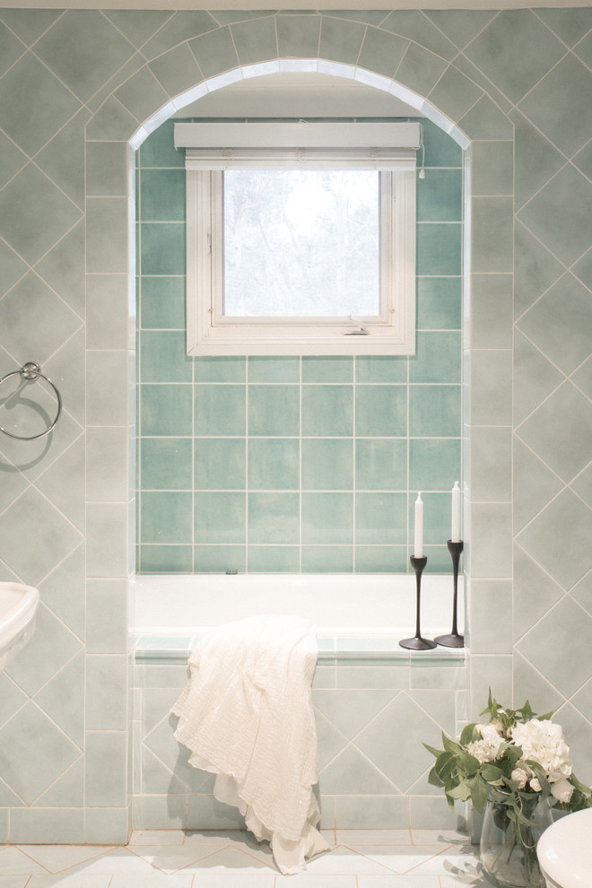 Photo of a traditional master bathroom in Sydney with flat-panel cabinets, blue cabinets, a drop-in tub, an alcove shower, a wall-mount toilet, cement tile, green walls, porcelain floors, a pedestal sink, tile benchtops, blue floor, a hinged shower door and green benchtops.