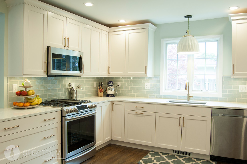 Example of a mid-sized transitional l-shaped dark wood floor eat-in kitchen design in Chicago with a drop-in sink, raised-panel cabinets, white cabinets, granite countertops, green backsplash, subway tile backsplash, stainless steel appliances and an island