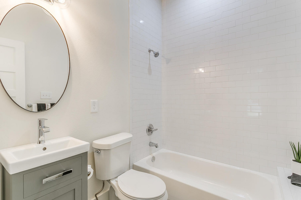 Drop-in bathtub - small transitional kids' white tile and subway tile porcelain tile, gray floor, single-sink and vaulted ceiling drop-in bathtub idea with shaker cabinets, gray cabinets, a one-piece toilet, white walls, a pedestal sink, quartz countertops, white countertops, a niche and a freestanding vanity