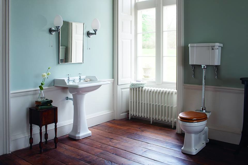 This is an example of a mid-sized traditional kids bathroom in Cambridgeshire with shaker cabinets, medium wood cabinets, a claw-foot tub, a curbless shower, a one-piece toilet, white tile, ceramic tile, white walls, porcelain floors, a pedestal sink and marble benchtops.