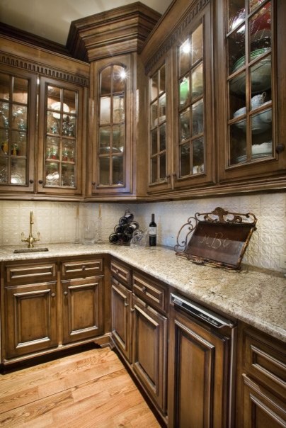 Photo of a large traditional u-shaped separate kitchen in Atlanta with a double-bowl sink, raised-panel cabinets, dark wood cabinets, quartzite benchtops, beige splashback, ceramic splashback, stainless steel appliances, dark hardwood floors, with island, multi-coloured floor and beige benchtop.