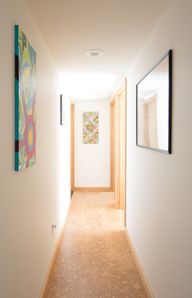 This is an example of a mid-sized midcentury hallway in Seattle with white walls, cork floors and beige floor.