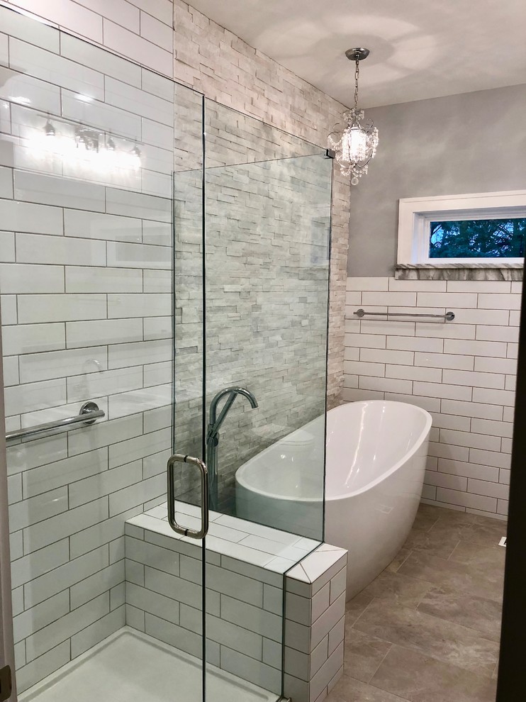 Design ideas for a mid-sized traditional master bathroom in Austin with shaker cabinets, grey cabinets, a freestanding tub, a corner shower, a two-piece toilet, white tile, ceramic tile, grey walls, porcelain floors, an undermount sink, marble benchtops, grey floor, a hinged shower door and multi-coloured benchtops.