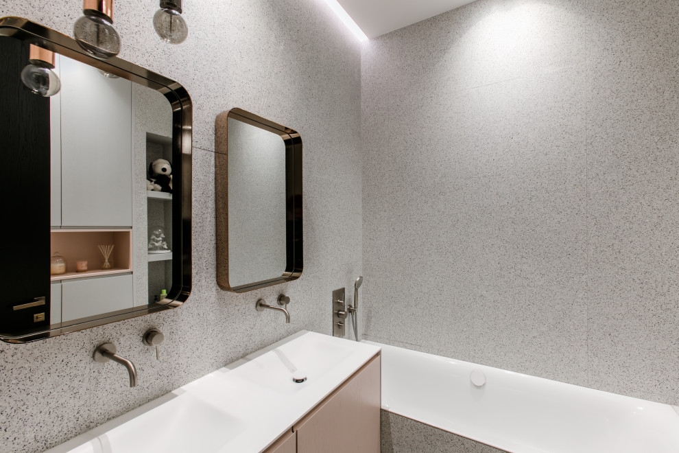 This is an example of a contemporary bathroom in Paris with flat-panel cabinets, a drop-in tub, a shower/bathtub combo, multi-coloured tile, multi-coloured walls and a trough sink.