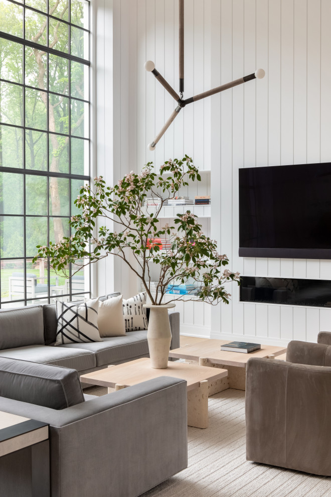 This is an example of a mid-sized transitional formal open concept living room in New York with white walls, light hardwood floors, a freestanding tv, brown floor, wood and planked wall panelling.