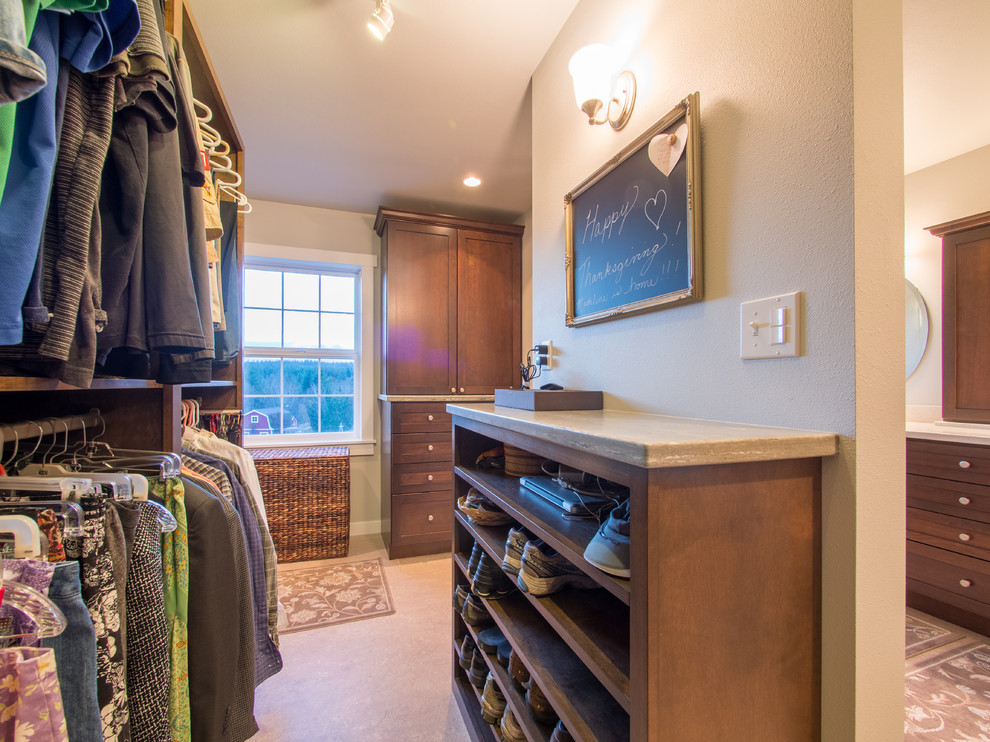 Mid-sized country gender-neutral walk-in wardrobe in Seattle with shaker cabinets, dark wood cabinets, linoleum floors and beige floor.