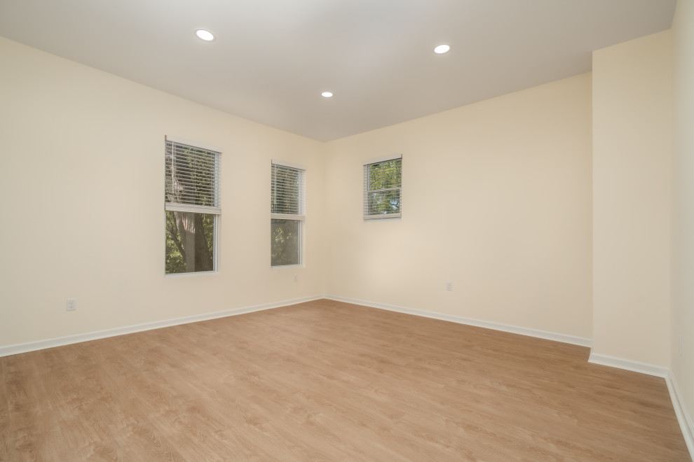 Exempel på ett mellanstort amerikanskt huvudsovrum, med beige väggar, vinylgolv och brunt golv