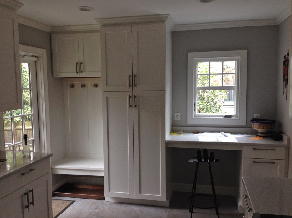 This is an example of a small traditional l-shaped eat-in kitchen in Boston with a double-bowl sink, shaker cabinets, white cabinets, quartz benchtops, stainless steel appliances, slate floors and no island.