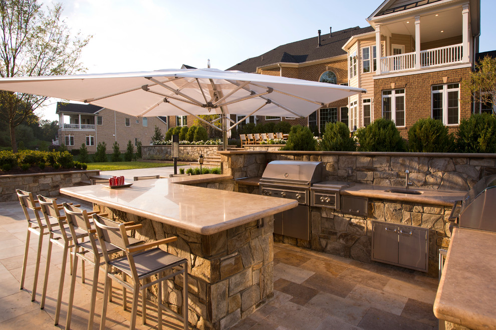 Design ideas for a large traditional backyard patio in DC Metro with natural stone pavers.