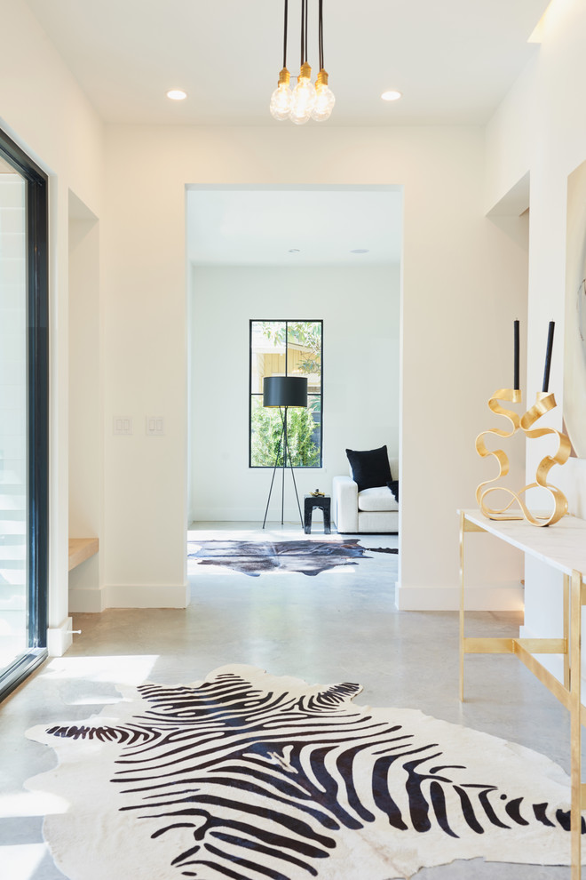 Foyer - mid-sized transitional concrete floor foyer idea in Austin with white walls