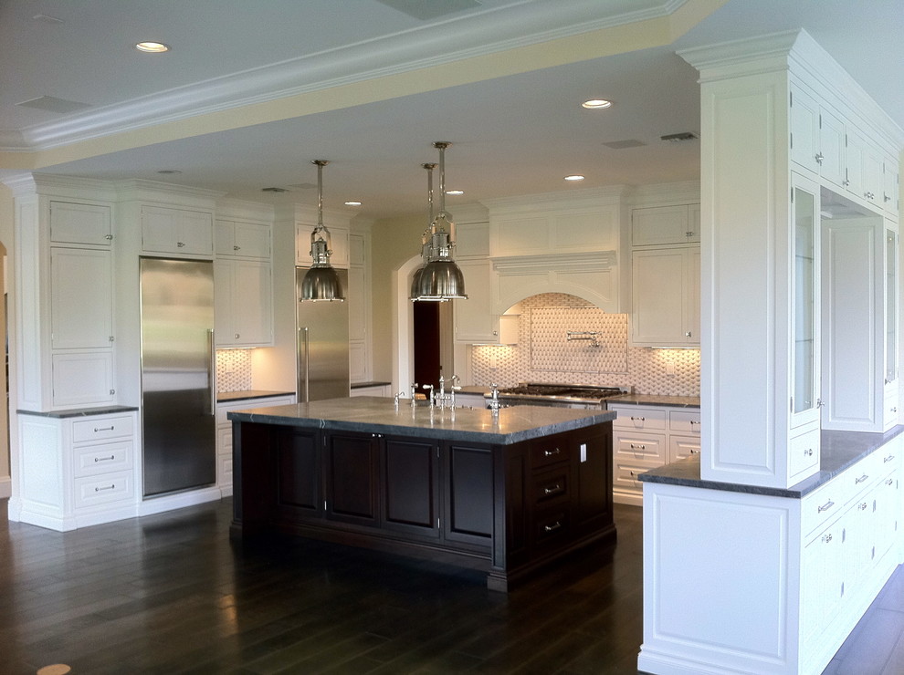 Open concept kitchen - large transitional u-shaped dark wood floor and brown floor open concept kitchen idea in Miami with a farmhouse sink, shaker cabinets, white cabinets, granite countertops, multicolored backsplash, stone tile backsplash, stainless steel appliances and an island