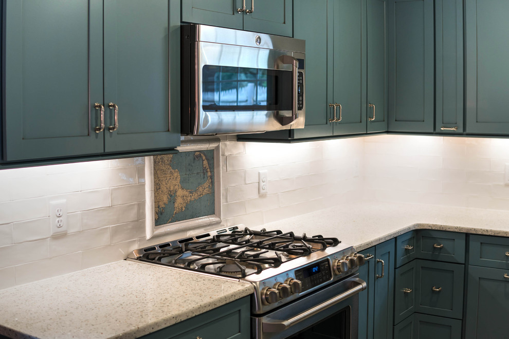 Small modern l-shaped kitchen pantry in Boston with a farmhouse sink, shaker cabinets, blue cabinets, recycled glass benchtops, white splashback, ceramic splashback, stainless steel appliances, ceramic floors, with island and beige floor.