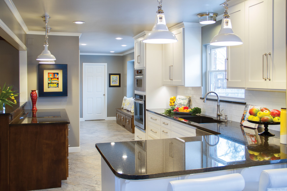 Inspiration for a transitional porcelain tile eat-in kitchen remodel with a double-bowl sink, shaker cabinets, white cabinets, granite countertops, white backsplash, subway tile backsplash and stainless steel appliances