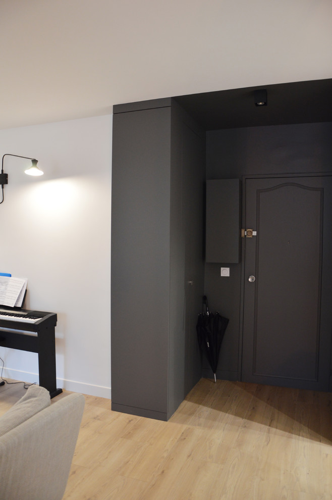 This is an example of a small contemporary mudroom in Paris with grey walls and laminate floors.