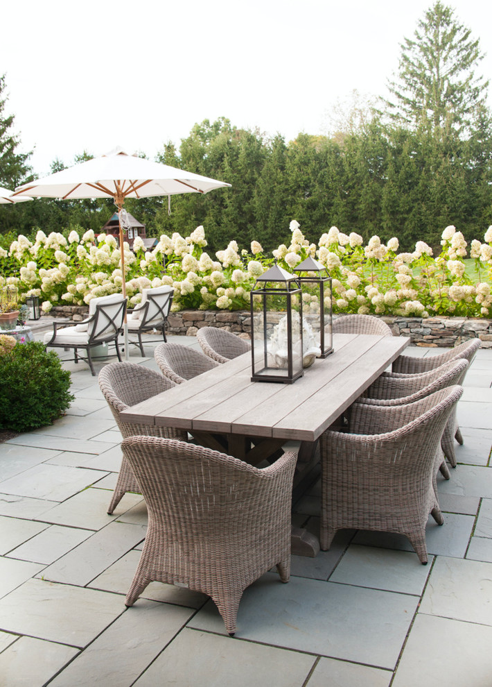 Photo of a traditional patio in New York with no cover and natural stone pavers.