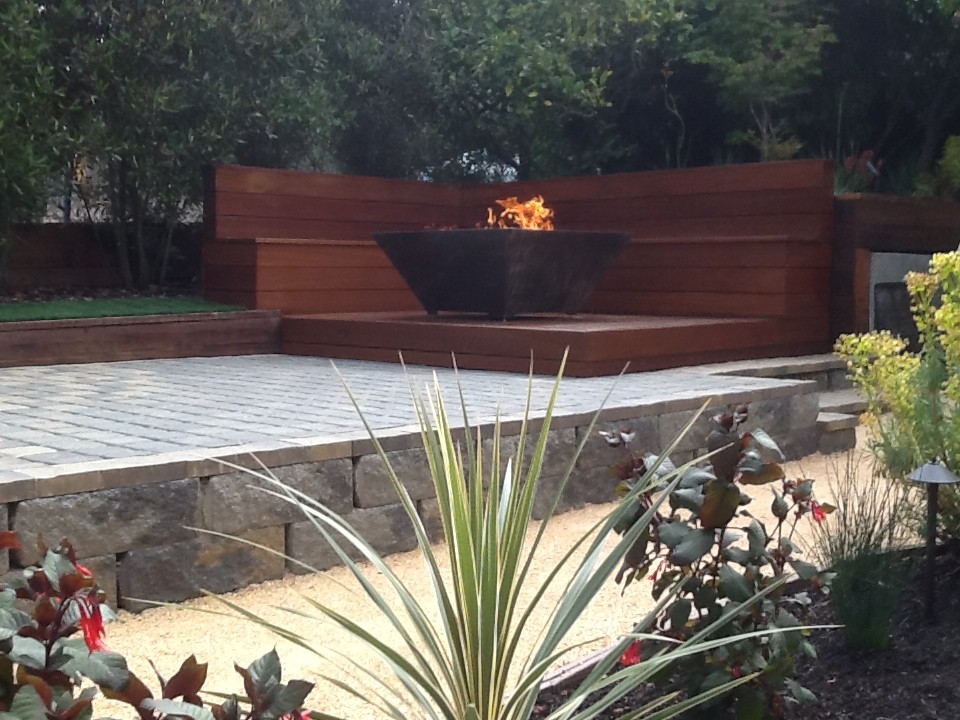 This is an example of a small contemporary backyard partial sun garden in San Francisco with concrete pavers and a fire feature.