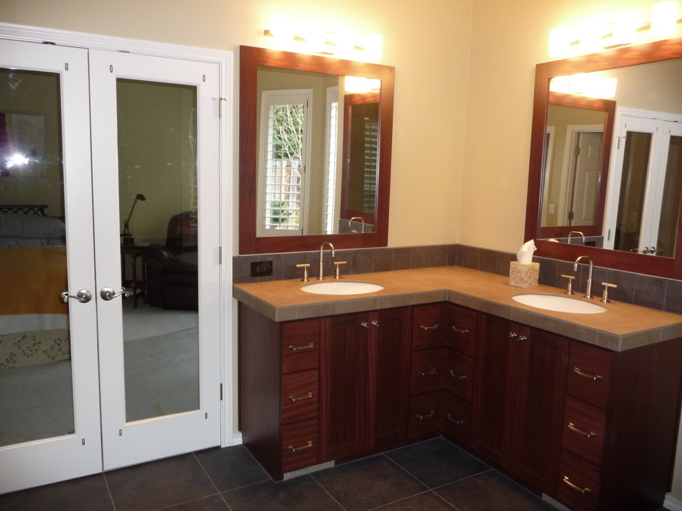 This is an example of a large contemporary master bathroom in Portland with an undermount sink, flat-panel cabinets, dark wood cabinets, tile benchtops, porcelain tile, a drop-in tub, an alcove shower and beige walls.