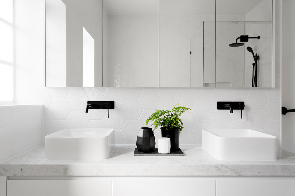 Photo of a large contemporary master bathroom in Melbourne with flat-panel cabinets, white cabinets, a drop-in tub, a corner shower, a one-piece toilet, white tile, ceramic tile, white walls, cement tiles, a vessel sink, marble benchtops, yellow floor, a hinged shower door and grey benchtops.