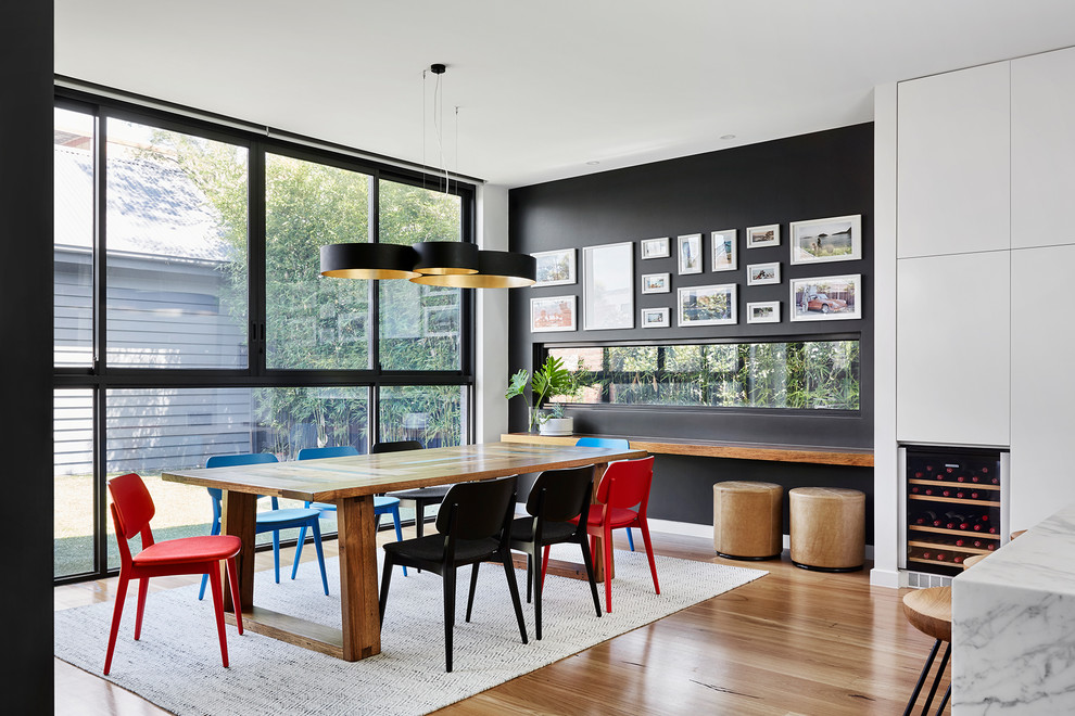 Inspiration for a contemporary dining room in Melbourne with black walls, light hardwood floors and beige floor.