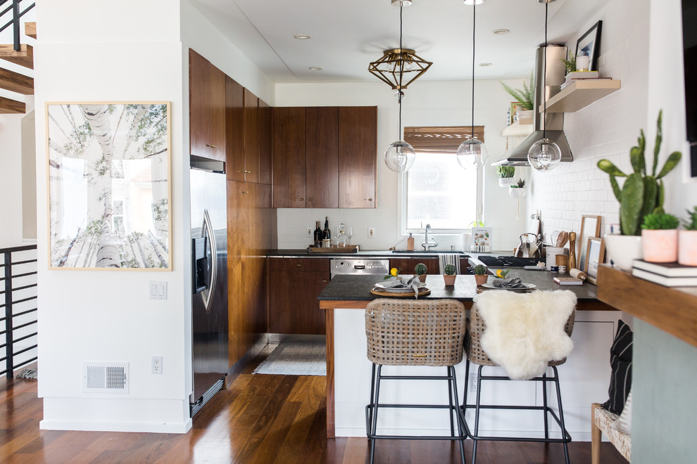 Mid-sized contemporary l-shaped open plan kitchen in San Francisco with a single-bowl sink, flat-panel cabinets, brown cabinets, concrete benchtops, white splashback, subway tile splashback, stainless steel appliances, dark hardwood floors, with island and brown floor.